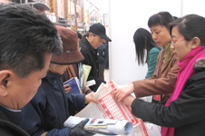 中國質量檢驗協會工作人員在2006年“3.15”咨詢活動現場向消費者發放資料